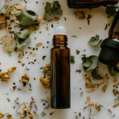 A flat lay of essential oil bottles surrounded by dried herbs, perfect for aromatherapy or natural remedy themes.