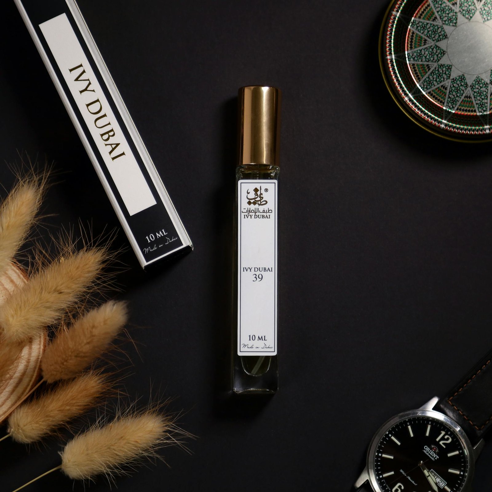 Stylish flat lay of IVY Dubai perfume bottle with elegant accessories on a dark background.