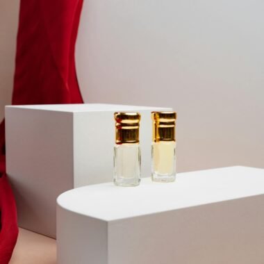 Stylish still life of luxury perfume bottles set against a red draped background, showcasing elegance.