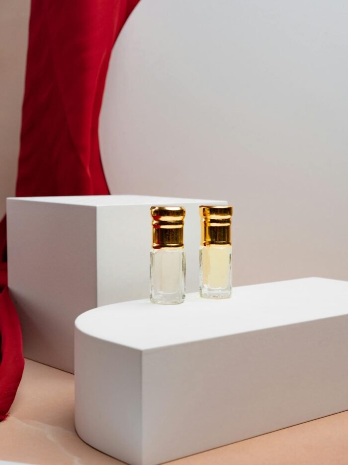 Stylish still life of luxury perfume bottles set against a red draped background, showcasing elegance.